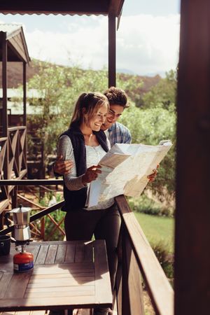 Man and woman reading map for finding nearest tourist attraction