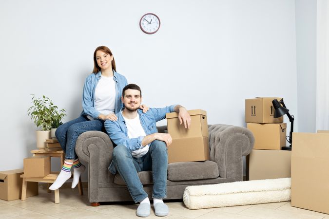 Moving concept, couple man and woman with boxes in apartment.