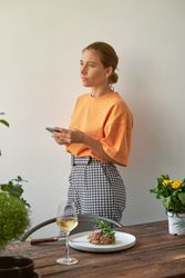Pensive young female having lunch in cozy kitchen
