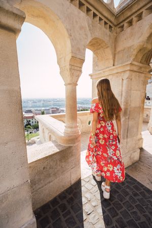Woman standing near columned marble fence