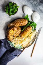 Top view of baked potato, spinach and cabbage salad on marble counter