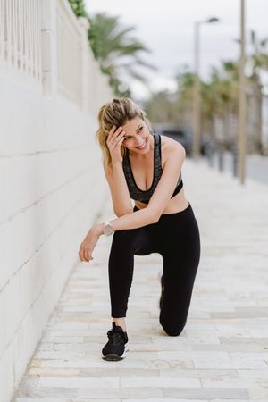 Satisfied sportswoman in active clothing smiling while exercising