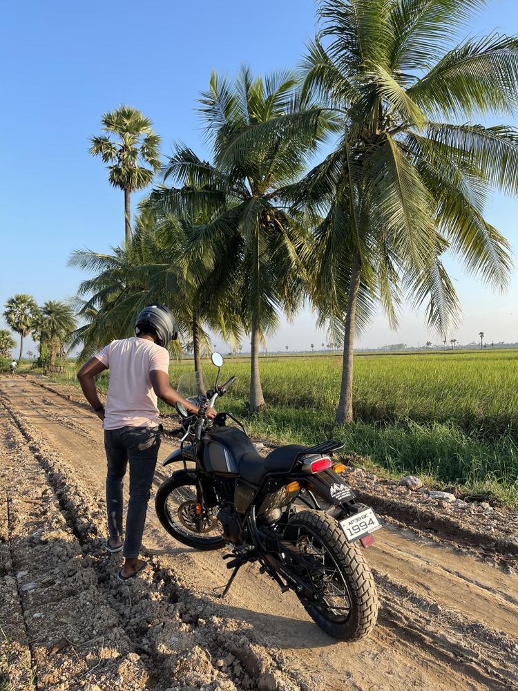 Man in light t-shirt standing next to motorcycle