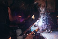 Professional welder in mask welding metal