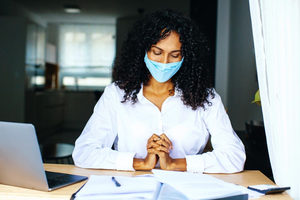 Content woman wearing a facemask reading over documents