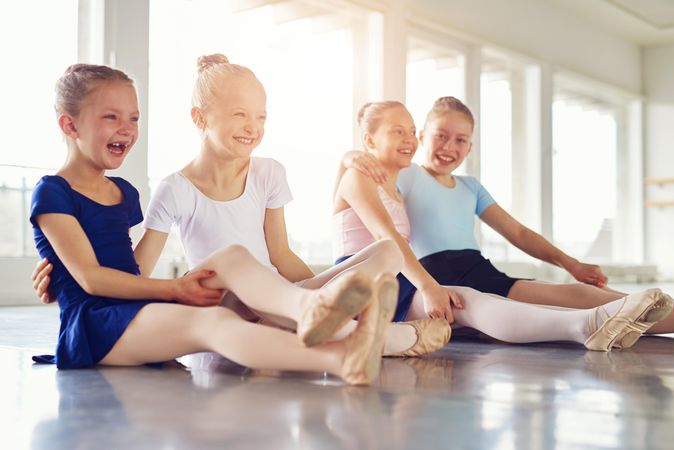 Girls sitting and smiling during ballet class