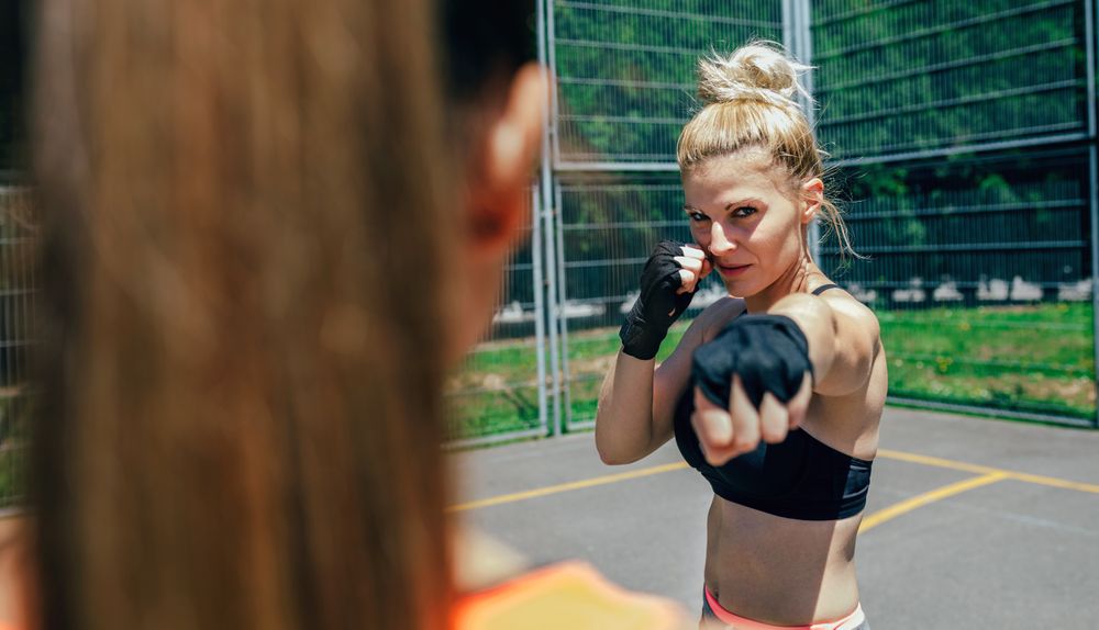 Sportswoman training boxing with her trainer