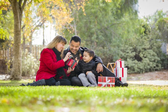 Family Enjoying Christmas Gifts in the Park Together