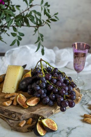 apes next to piece of cheese on cutting boards near pink flowers