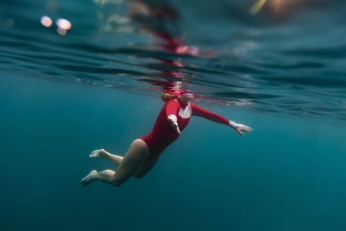 Woman diving in blue waving water