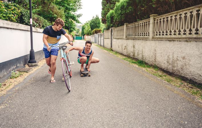 Two men having fun riding bike and skateboard