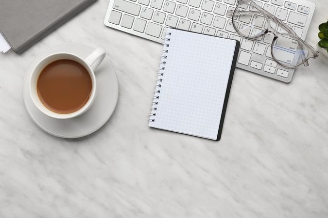 Notebook, Coffee, and Computer Keyboard on Table