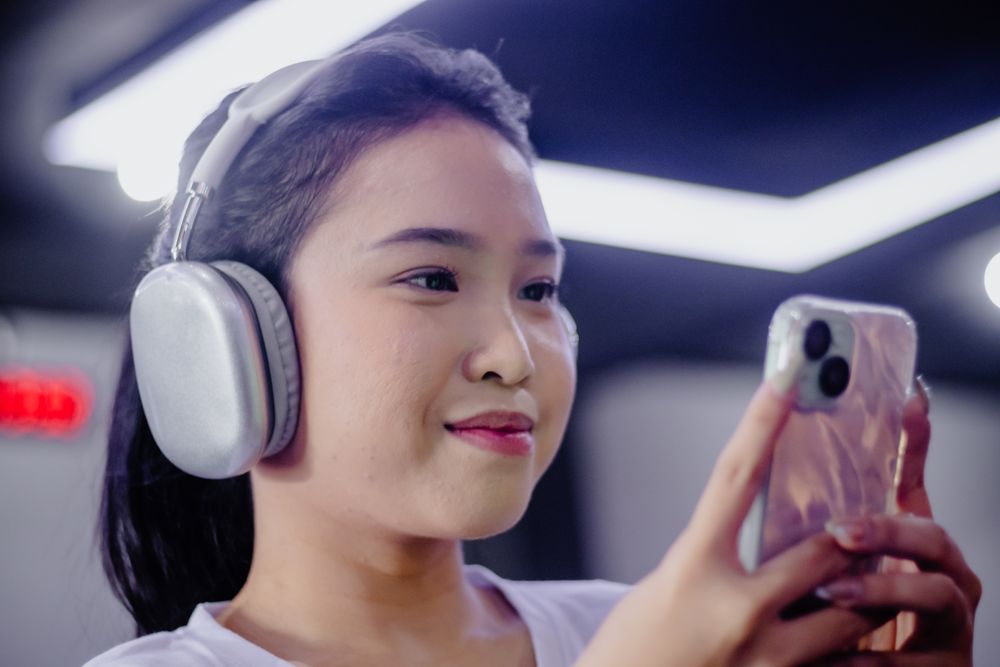 Young Woman Enjoying Entertainment with Phone and Wireless Headphones