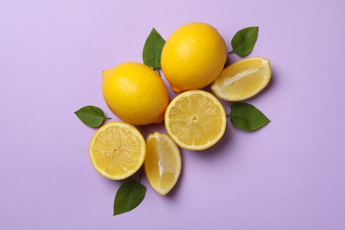 Fresh lemons on violet background, top view. Ripe fruit