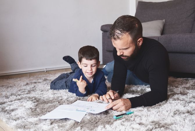 Father and son drawing on floor