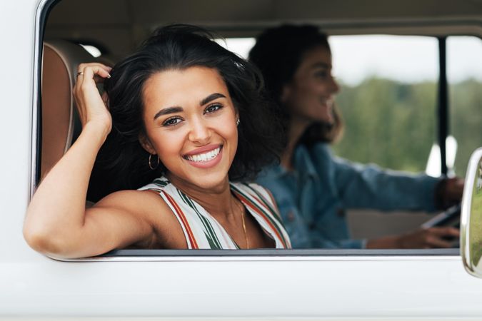 Beautiful woman smiling at the camera from the passenger seat of a van