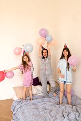 Family in party hats celebrating on bed at home
