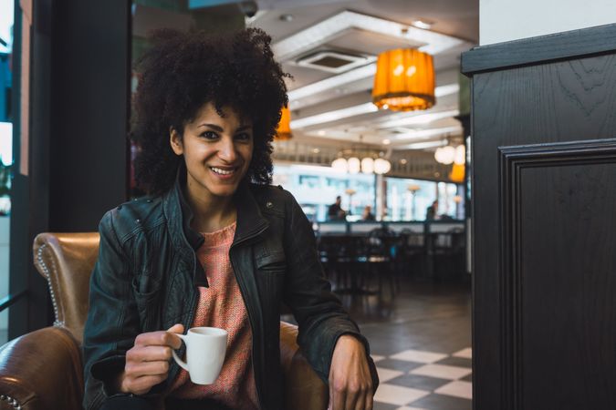 Black woman with afro hair drinking a coffee