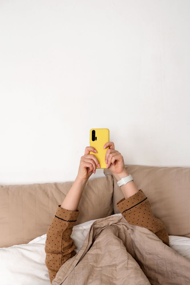Person using smartphone in bed