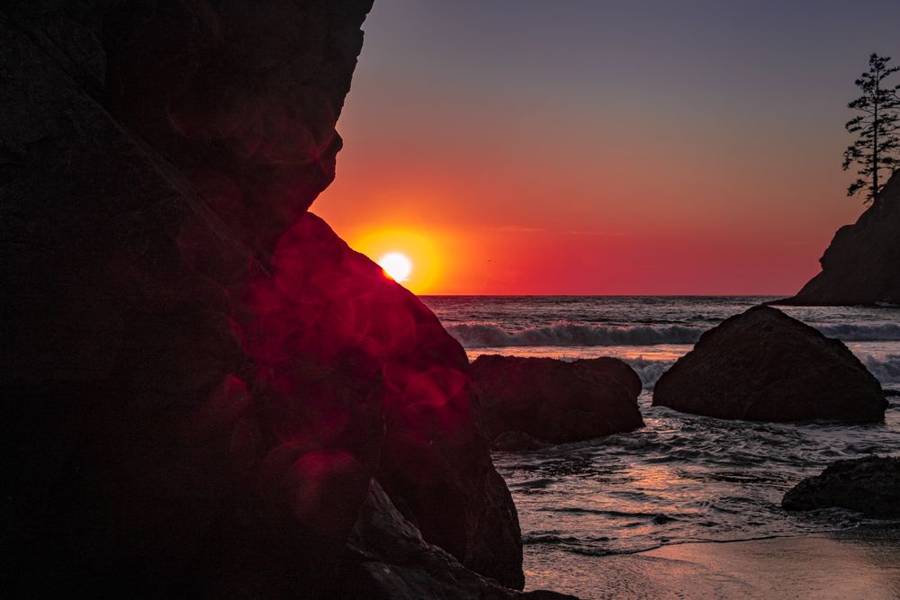 Sunset seen behind cliffs of rocky beach