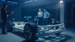 Automobile Design Engineers Talking while Working on Electric Car Chassis Prototype.