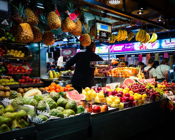 Man standing at fruit stand in street market