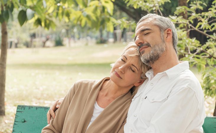 Mature couple relaxing and sitting together in a public park