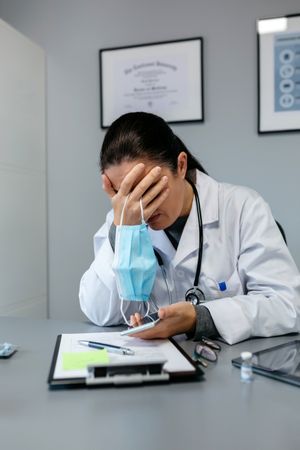Worried female doctor with hands on face
