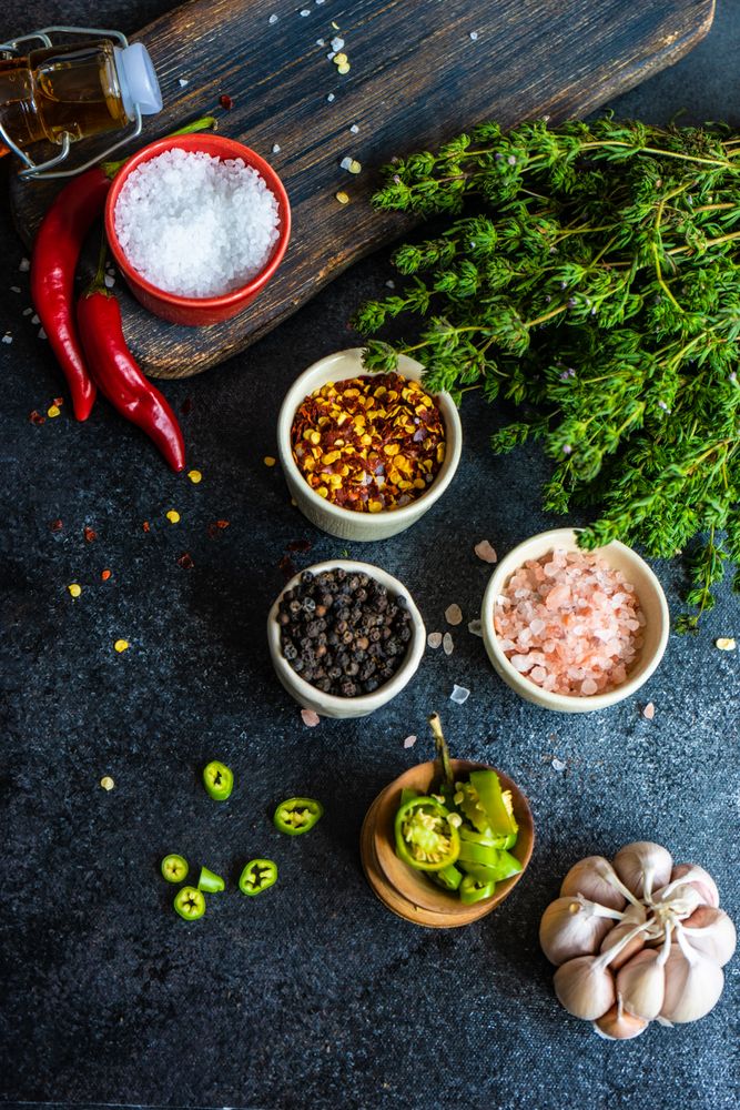 Variety of seasoning and herbs on dark counter