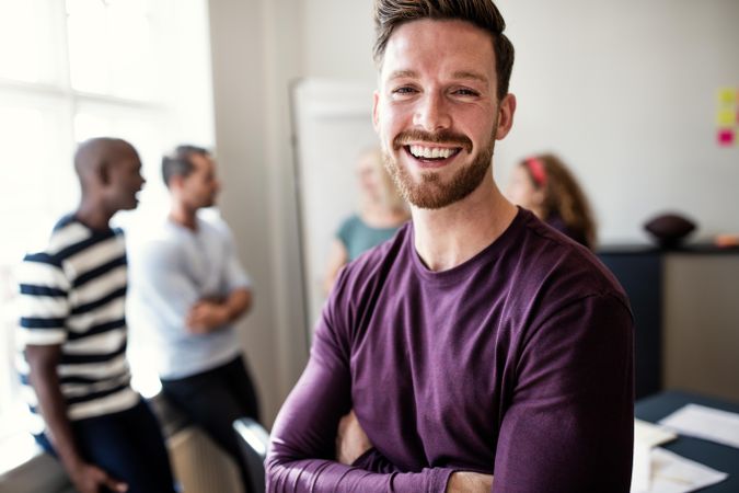 Man in purple shirt smiling in office