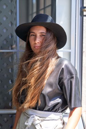 Stylish woman in hat looking at camera