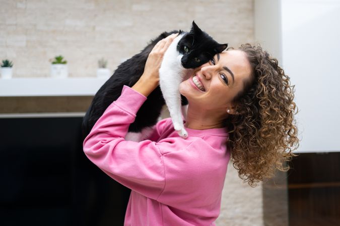 Happy woman hugging cute cat at home