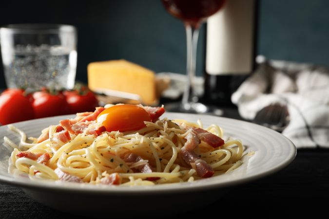 Composition with plate of tasty pasta on wooden background, close up