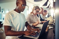 Serious businessman working on his laptop in an open office