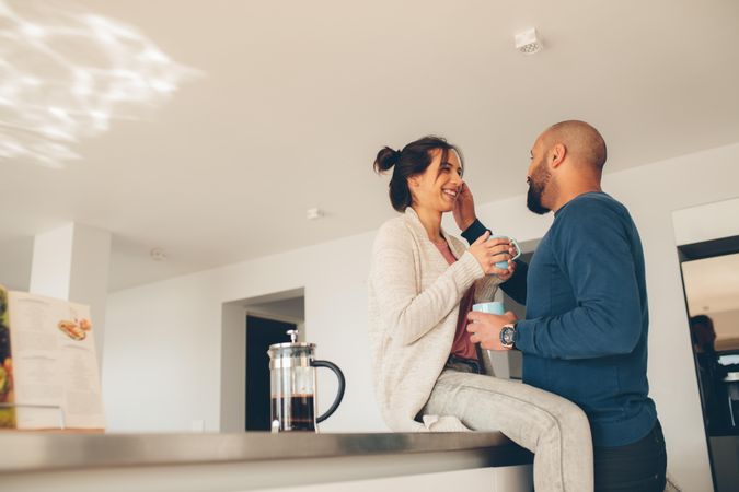 Young couple having coffee together at home in the kitchen