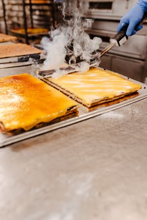 Crop confectioner spilling sugar on cake