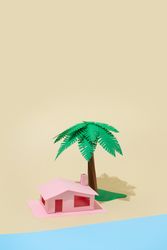 Palm tree and pink house made of paper on beige background