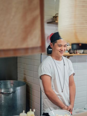 Asian male cook standing in kitchen