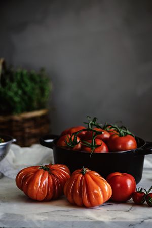 Ripe fresh tomatoes in pot on table