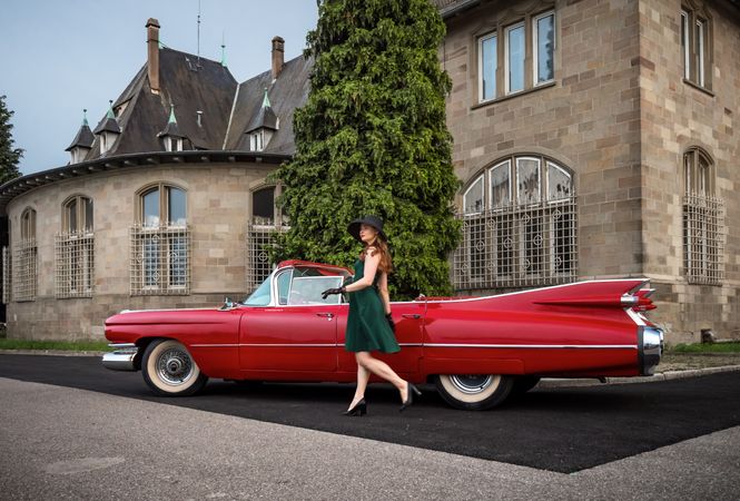 Old-timer red Cadillac and a woman in vintage attire