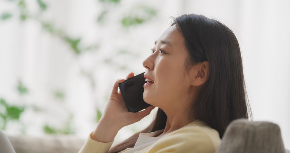 Smiling South Korean Woman is Having a Thoughtful Phone Conversation, Sharing Happy Stories of Love and Friendship