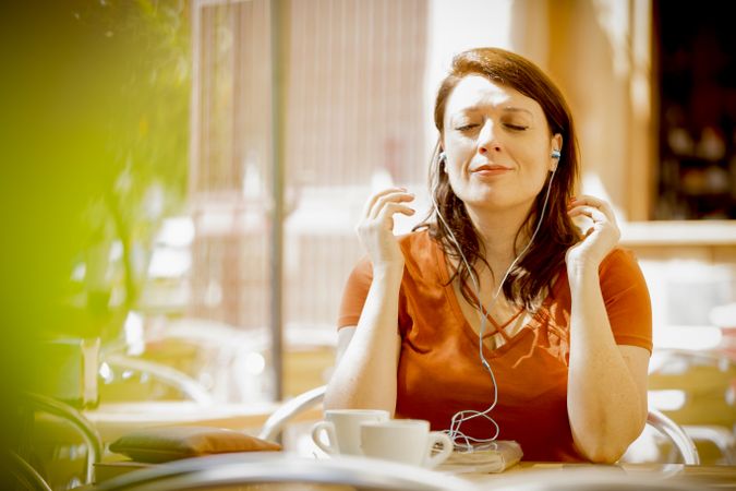 Casual female with closed eyes listening to music