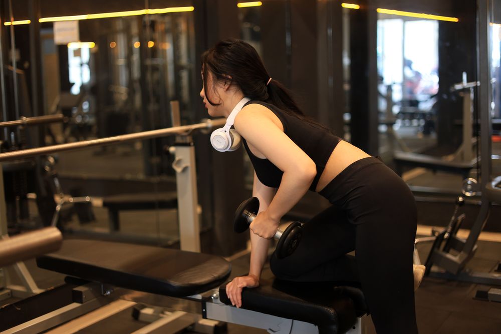 Young Woman Lifting Dumbbell in the Gym
