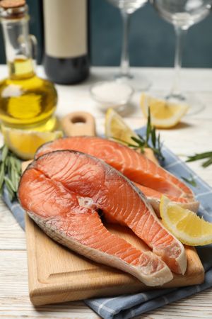 Composition with salmon meat and spices on wooden background, close up