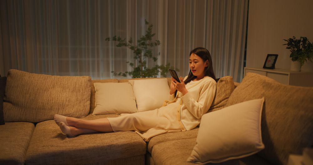 Young South Korean Woman Engaged and Connected Online, Enjoying Leisure Time with Her Smartphone