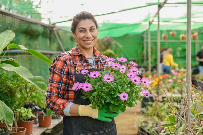 Cheerful gardener with bouquet of flowers