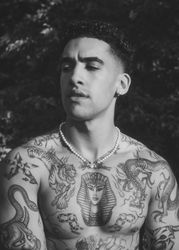 B&W portrait of tattooed shirtless male with eyes closed