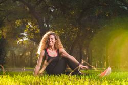 Happy woman stretching on sunny meadow