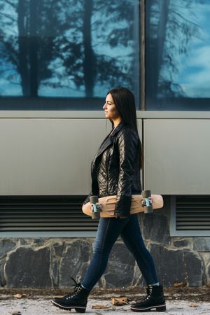 Young woman posing with skateboard