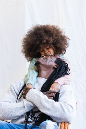 Black man carrying daughter on hands